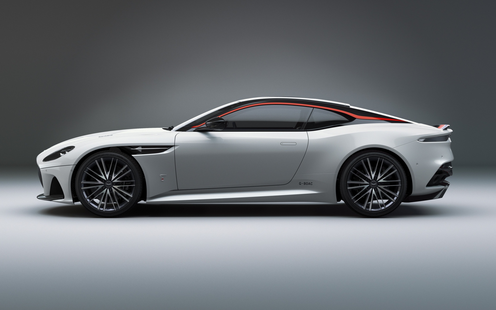 Серебристый автомобиль Aston Martin DBS Superleggera 2019 года вид сбоку