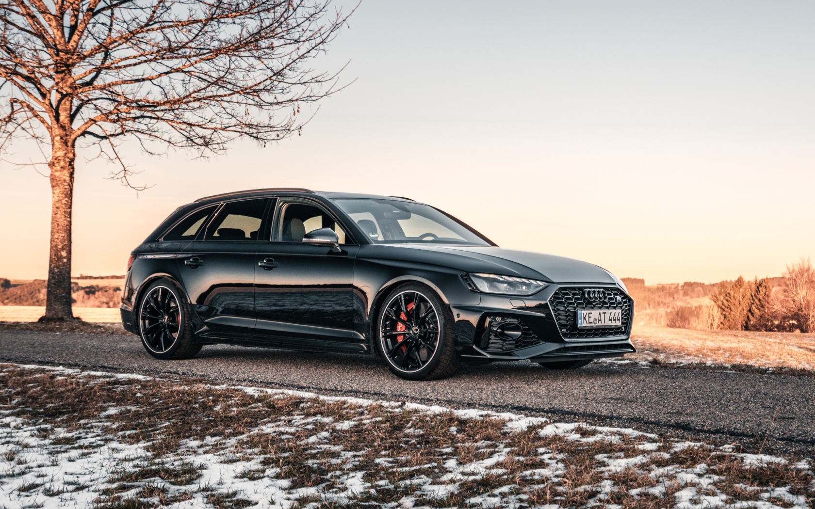Черный автомобиль  Audi RS 4 Avant 2020 года на дороге у дерева