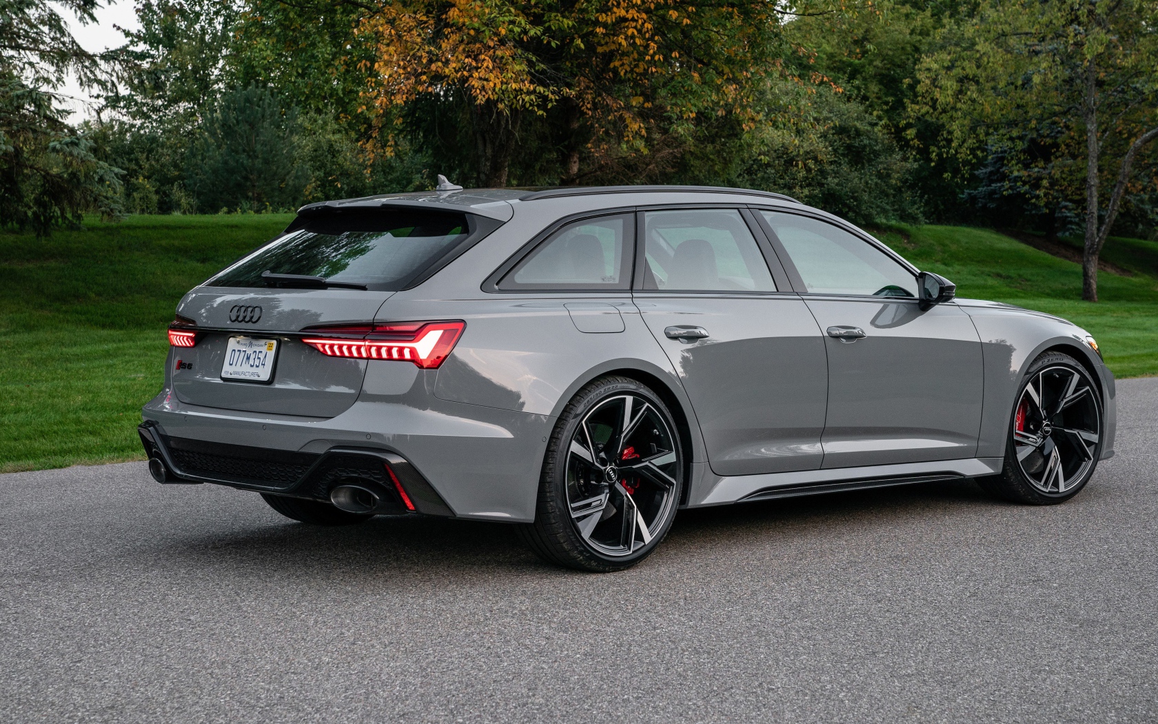 Серебристый автомобиль Audi RS 6 Avant, 2021 года вид сзади