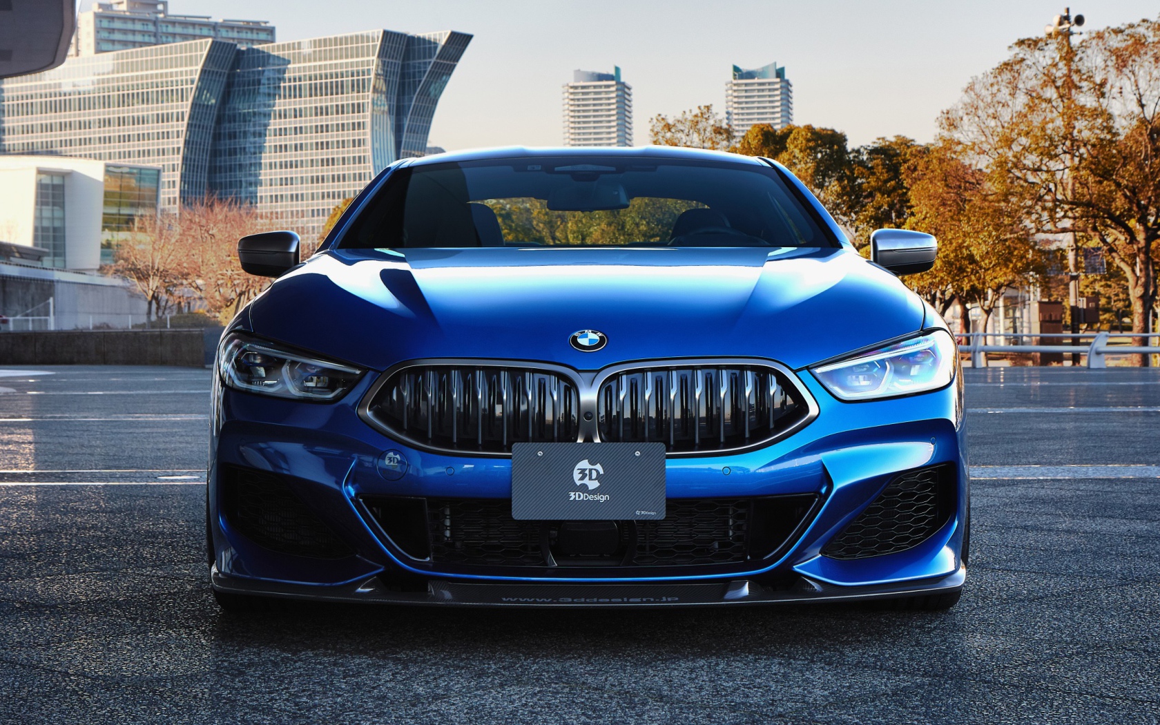 Синий автомобиль  BMW M850i XDrive Coupe 2020 года на фоне города 