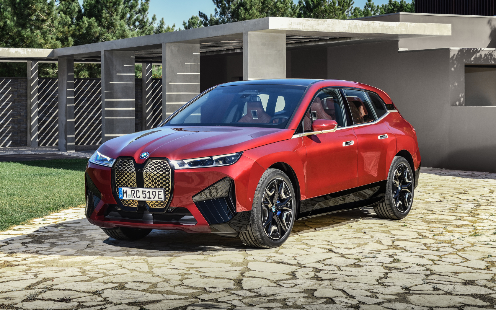 Красный кроссовер BMW IX Sport 2021 года у дома