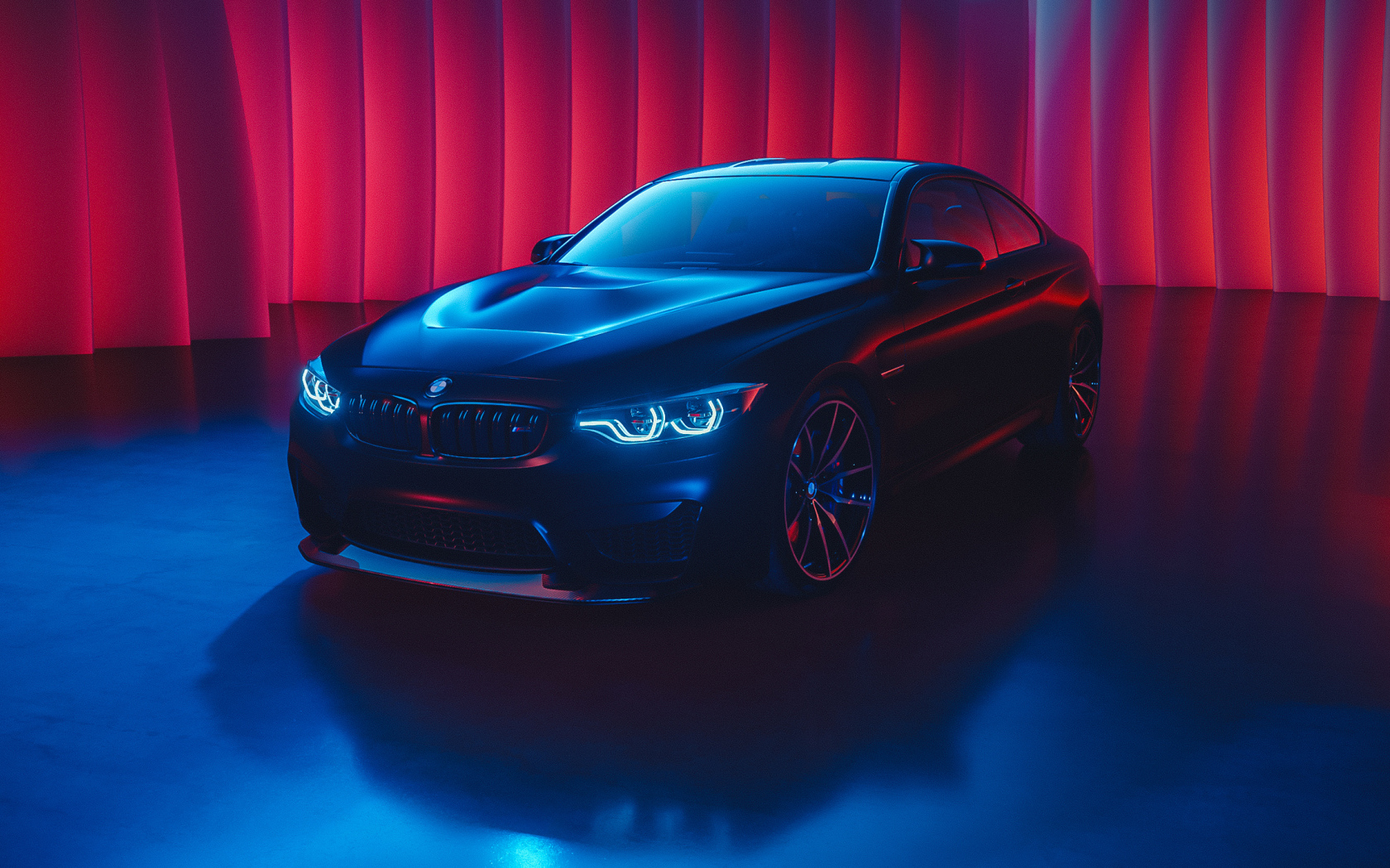 Черный автомобиль BMW M4 с включенными фарами