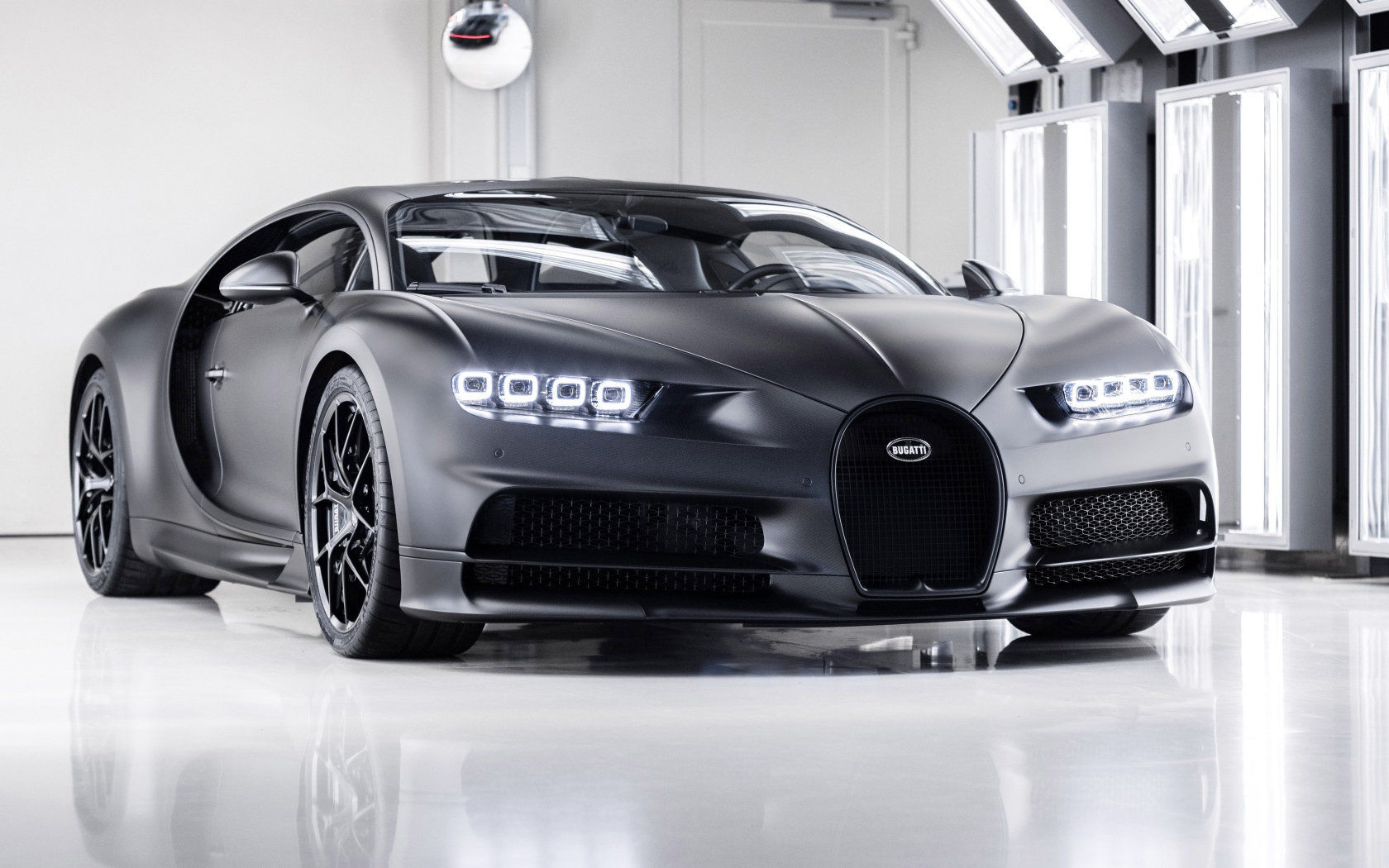 Автомобиль bugatti chiron 2020 года с включенными фарами