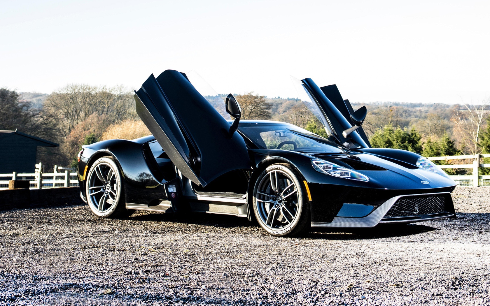 Черный спортивный автомобиль Ford GT с открытыми дверями