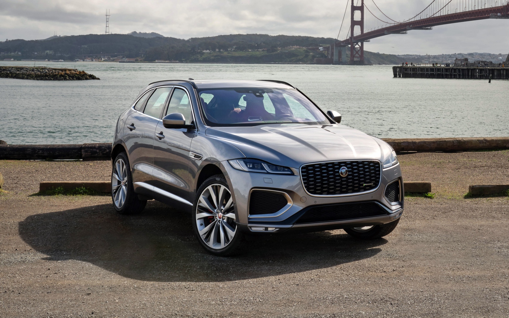 Серебристый автомобиль Jaguar F-Pace R-Dynamic 2020 года у реки 