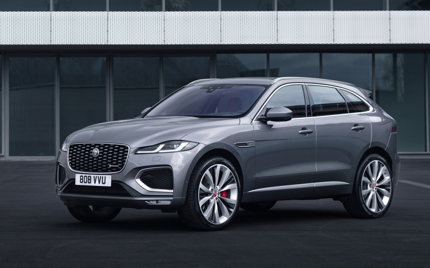 Серебристый автомобиль Jaguar F-Pace R-Dynamic 2020 года у здания 
