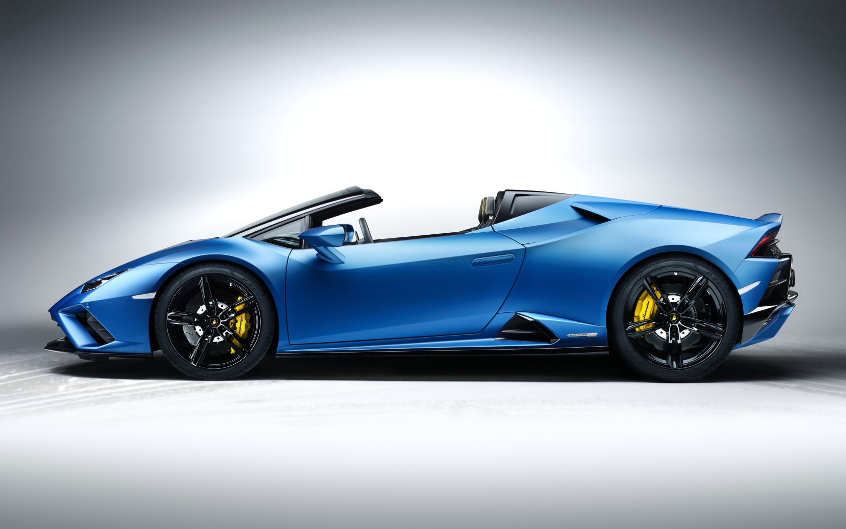 Дорогой быстрый автомобиль Lamborghini Huracan EVO RWD Spyder 2020 года на сером фоне 