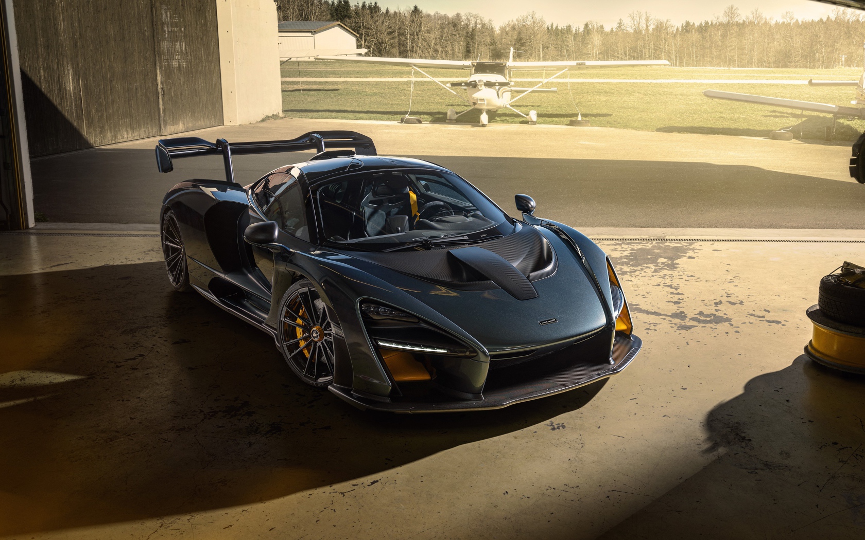 Черный автомобиль  McLaren Senna 2020 года на аэродроме 