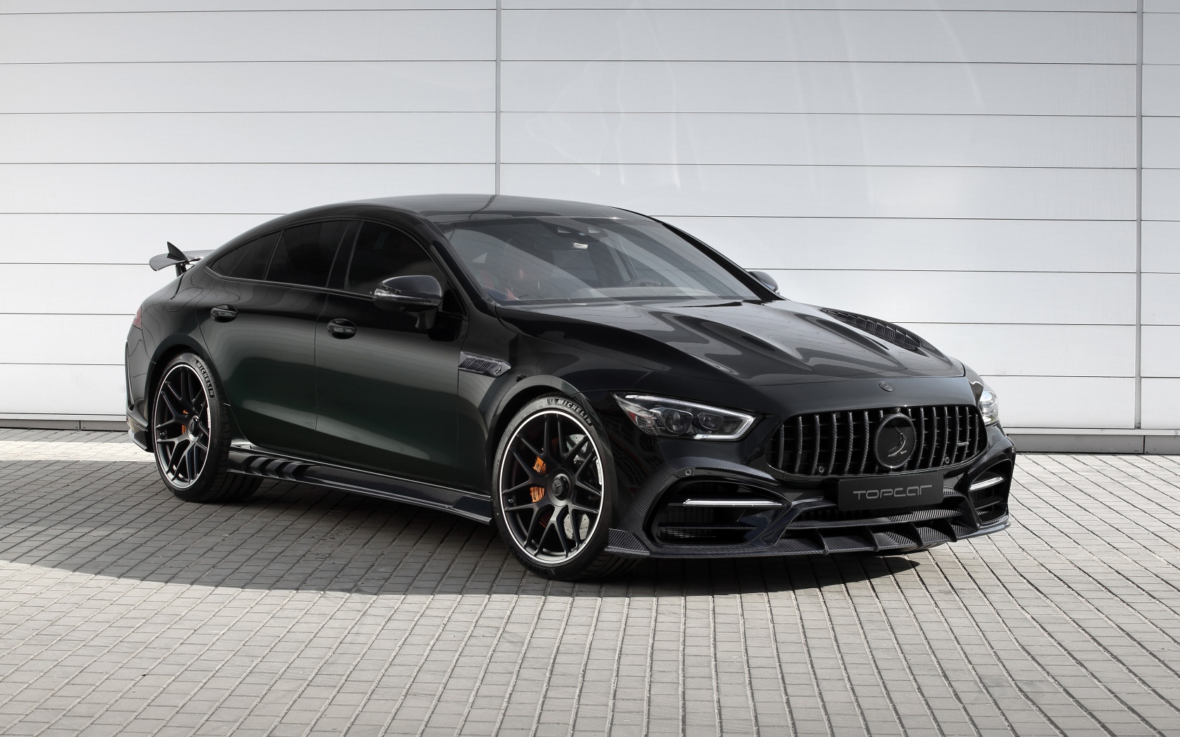 Черный автомобиль  Mercedes-AMG GT 63 S 4MATIC+ 4-Door Coupé Inferno 2020 года у гаража
