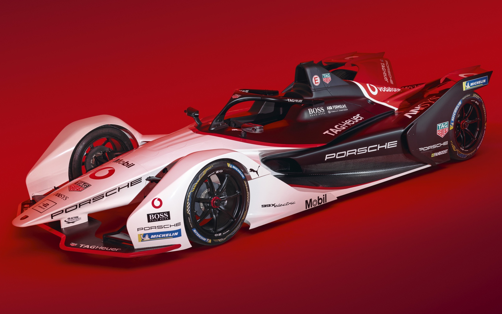 Гоночный автомобиль Porsche 99X Electric 2019 года на красном фоне