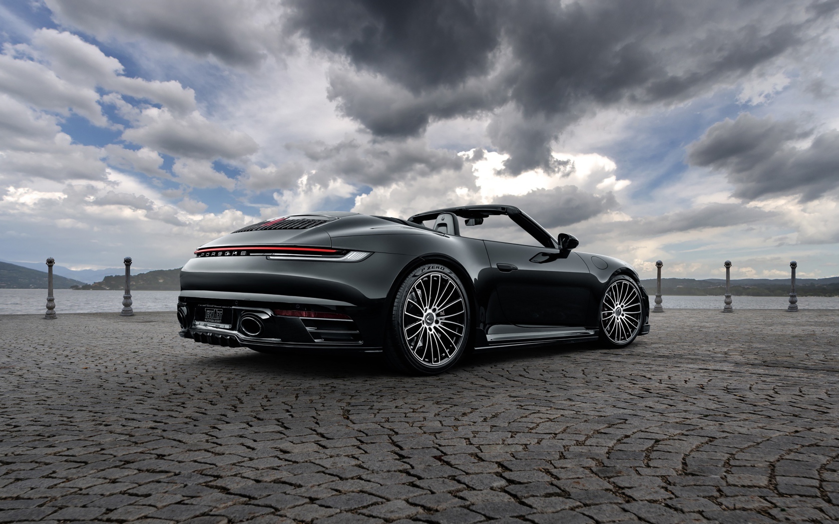 Черный автомобиль Porsche 911 Carrera 4S Cabriolet 2020 года под грозовым небом