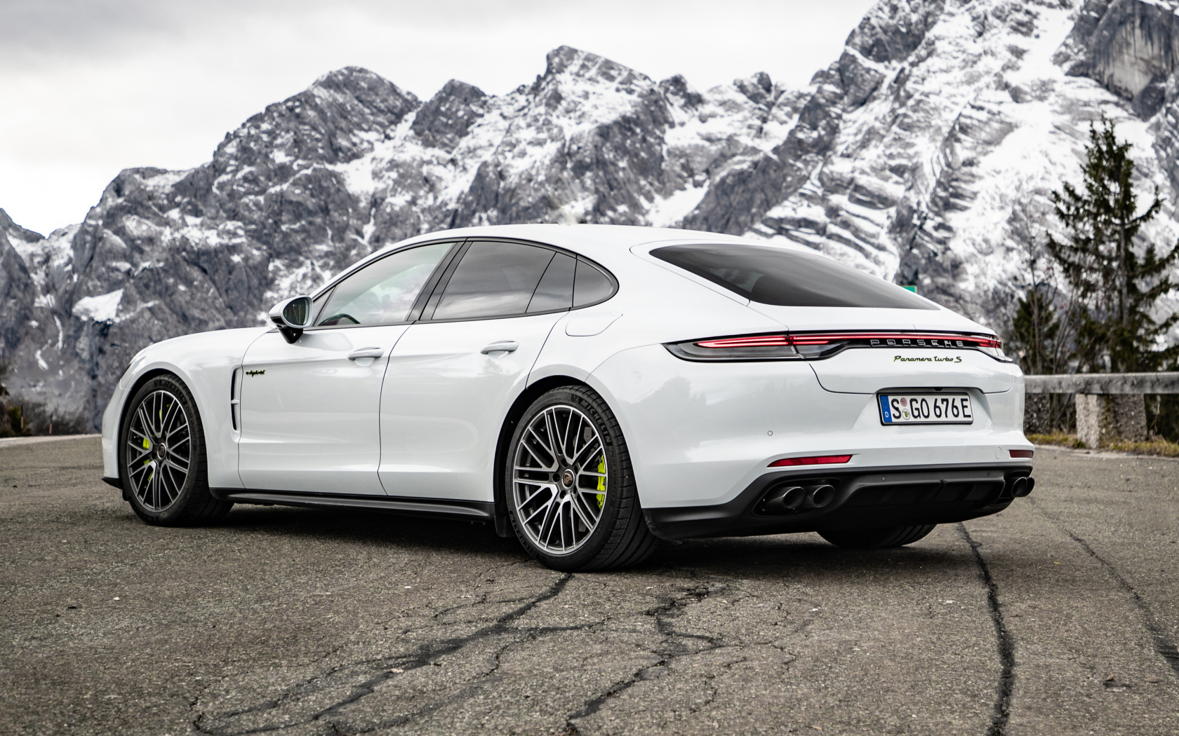 Белый автомобиль Porsche Panamera Turbo S E-Hybrid 2021 года на фоне гор