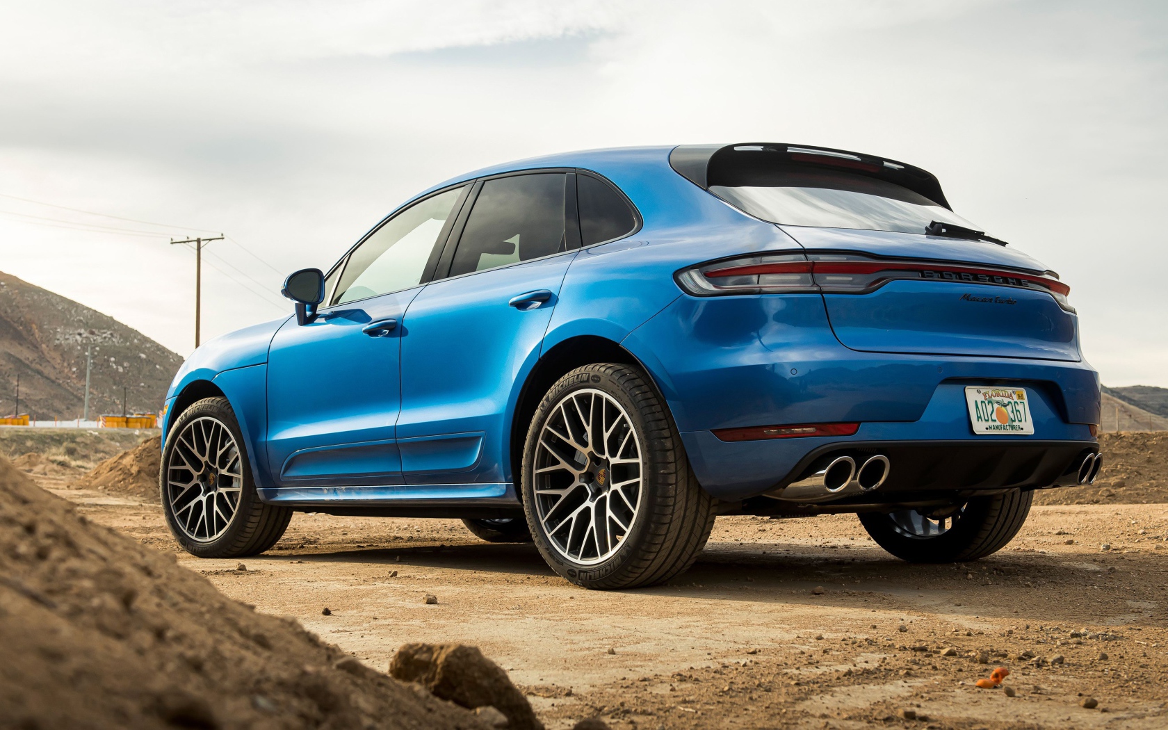 Синий автомобиль  Porsche Macan Turbo, 2020 года вид сзади 