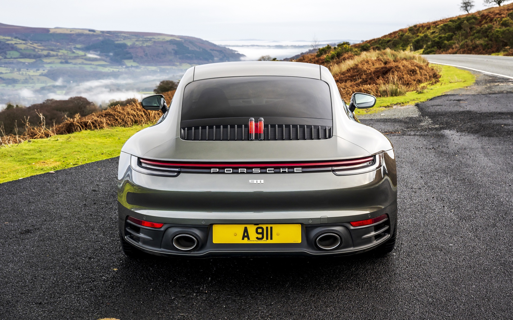 Автомобиль Porsche 911 Carrera на дороге у обрыва