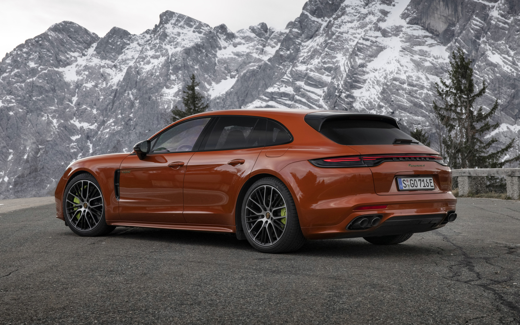 Красный автомобиль Porsche Panamera 4 E-Hybrid 2021 года на фоне гор