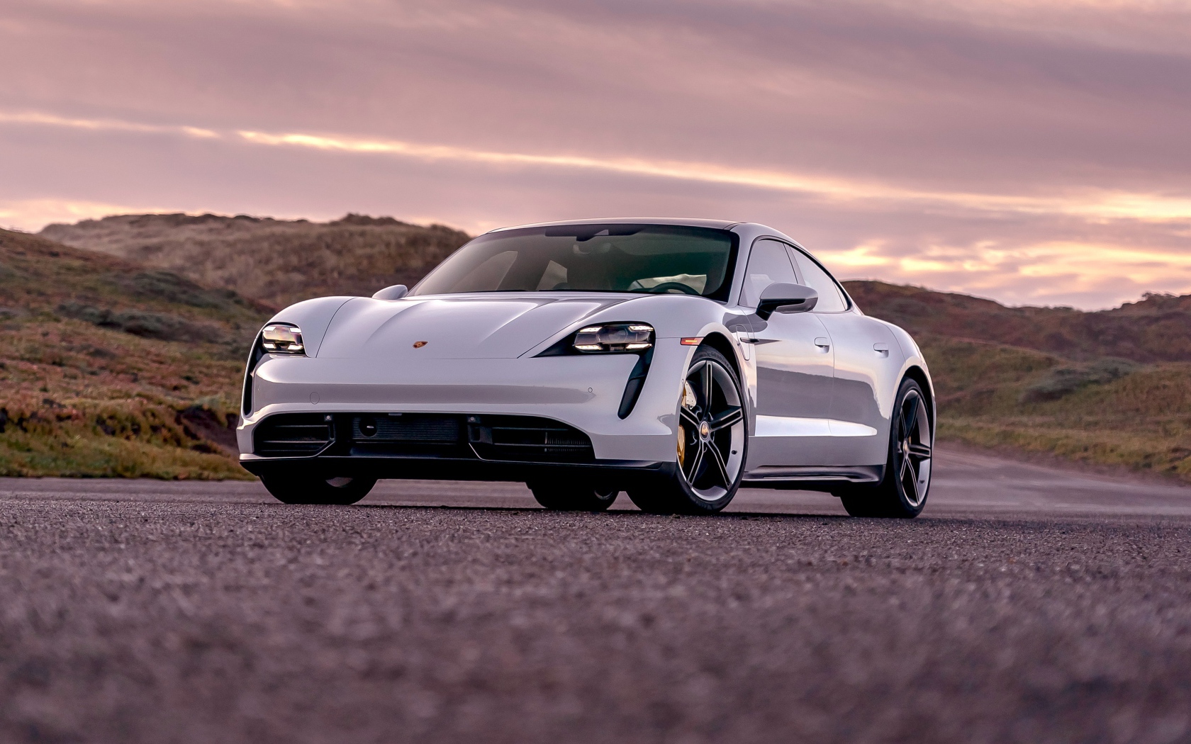 Серебристый автомобиль Porsche Taycan Turbo S 2020 года на фоне неба