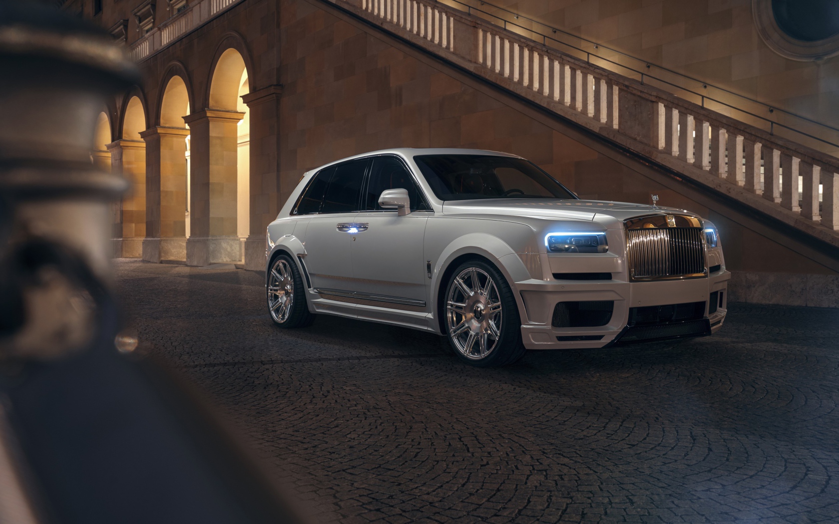 Белый автомобиль  Rolls-Royce Cullinan 2020 года у лестницы