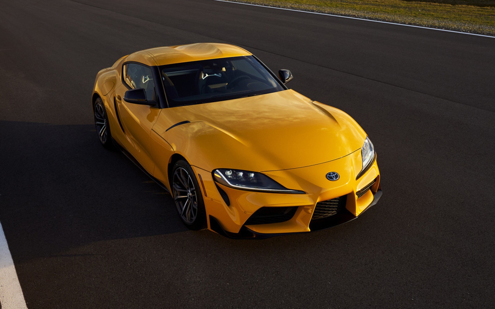 Желтый автомобиль  Toyota GR Supra, 2021 года на трассе 