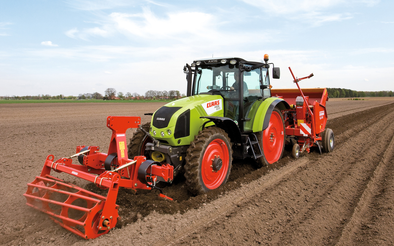 Большой комбайн сеет в поле 