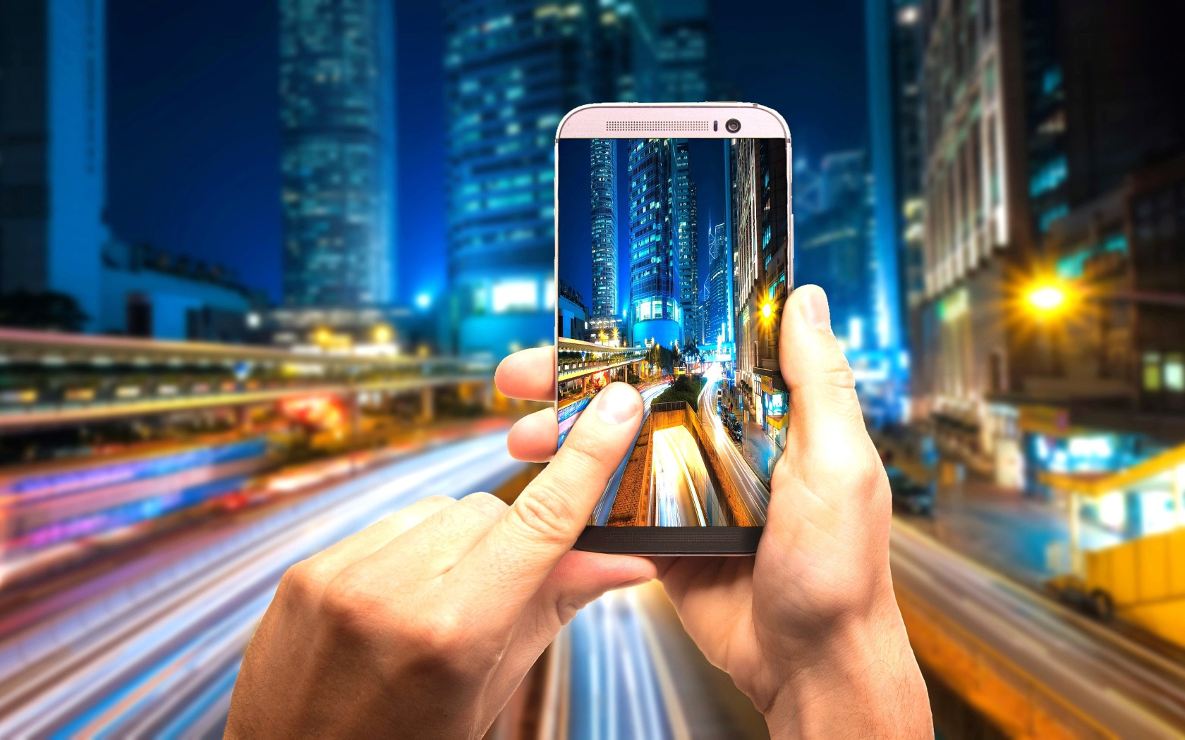 Мужчина делает фото ночного города на смартфон 