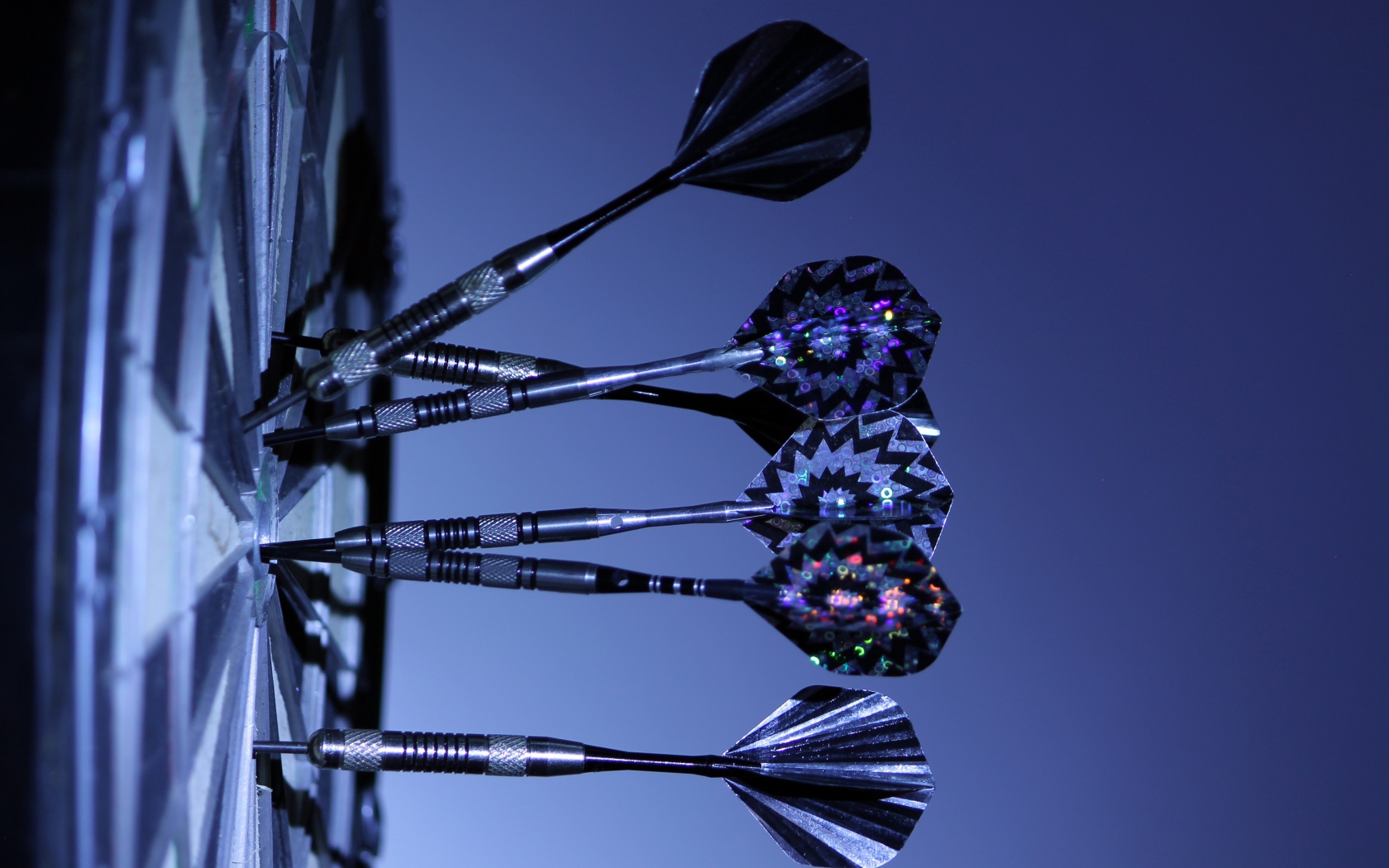Дротики в доске для дартс на синем фоне 