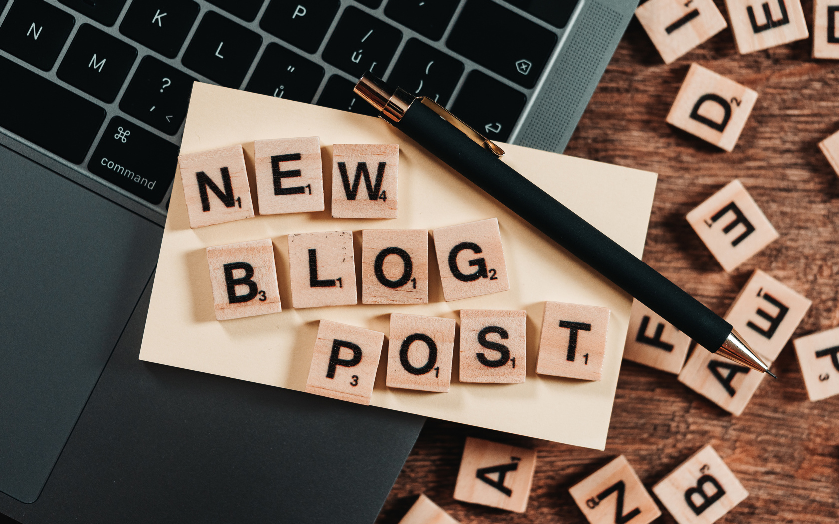Надпись на английском New Blog Post возле ноутбука с ручкой 