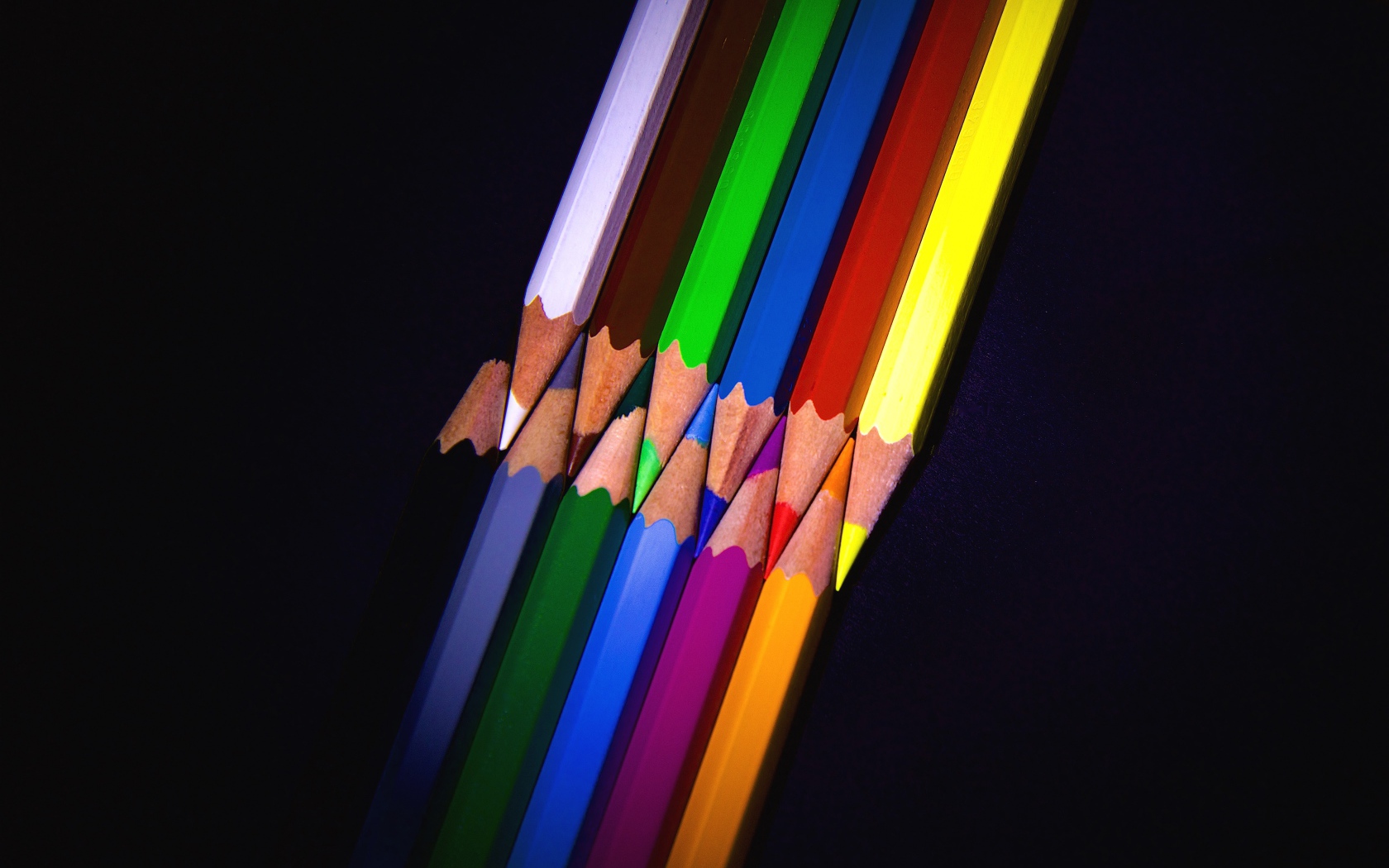 Разноцветные острые карандаши на черном фоне