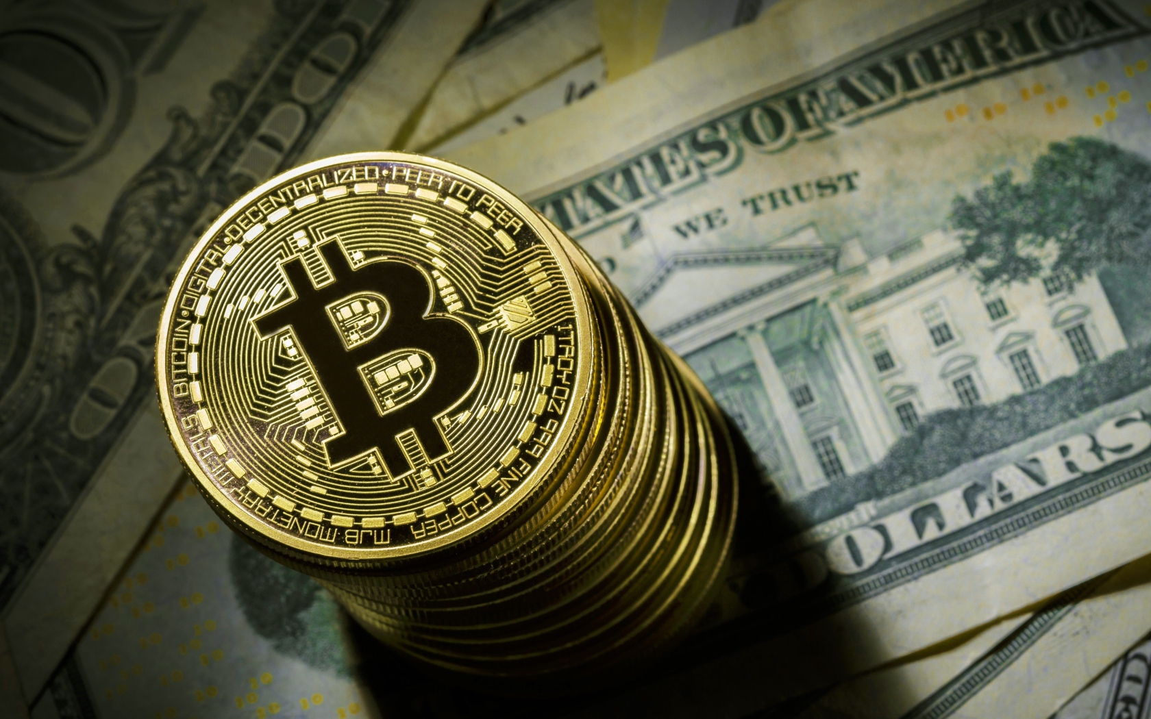 Золотые монеты биткоин лежат на долларах