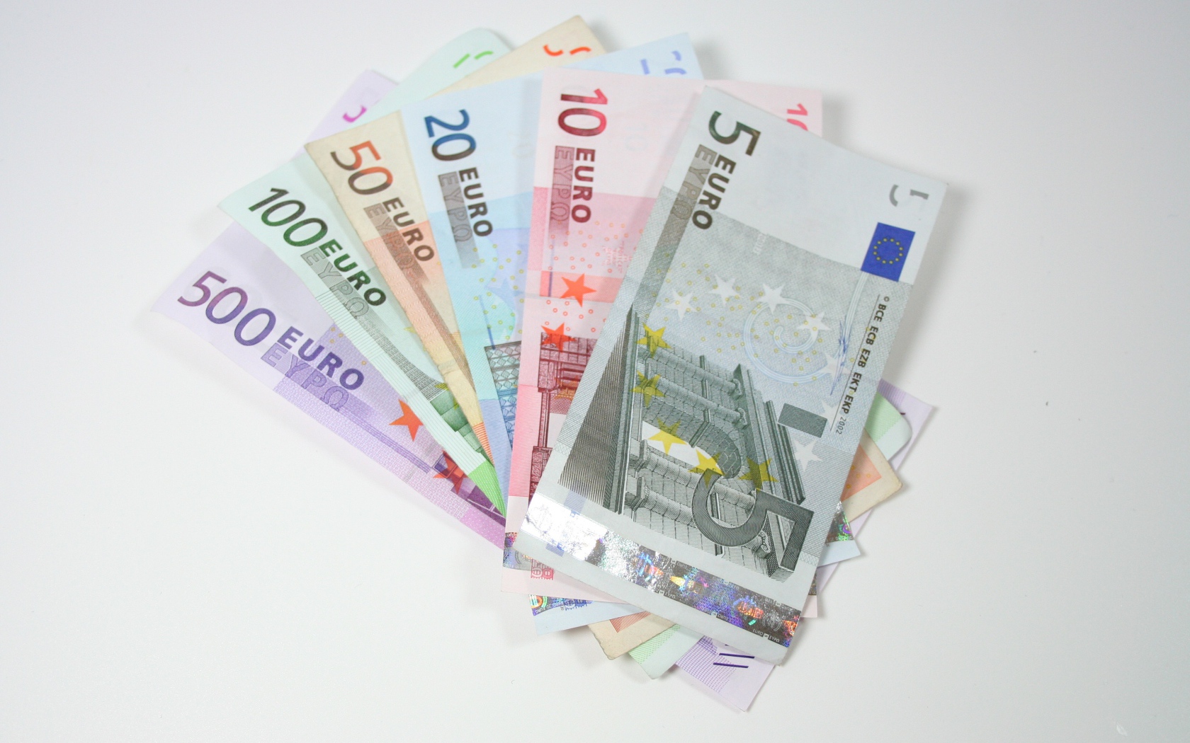 Купюры евро разным номиналом на сером фоне
