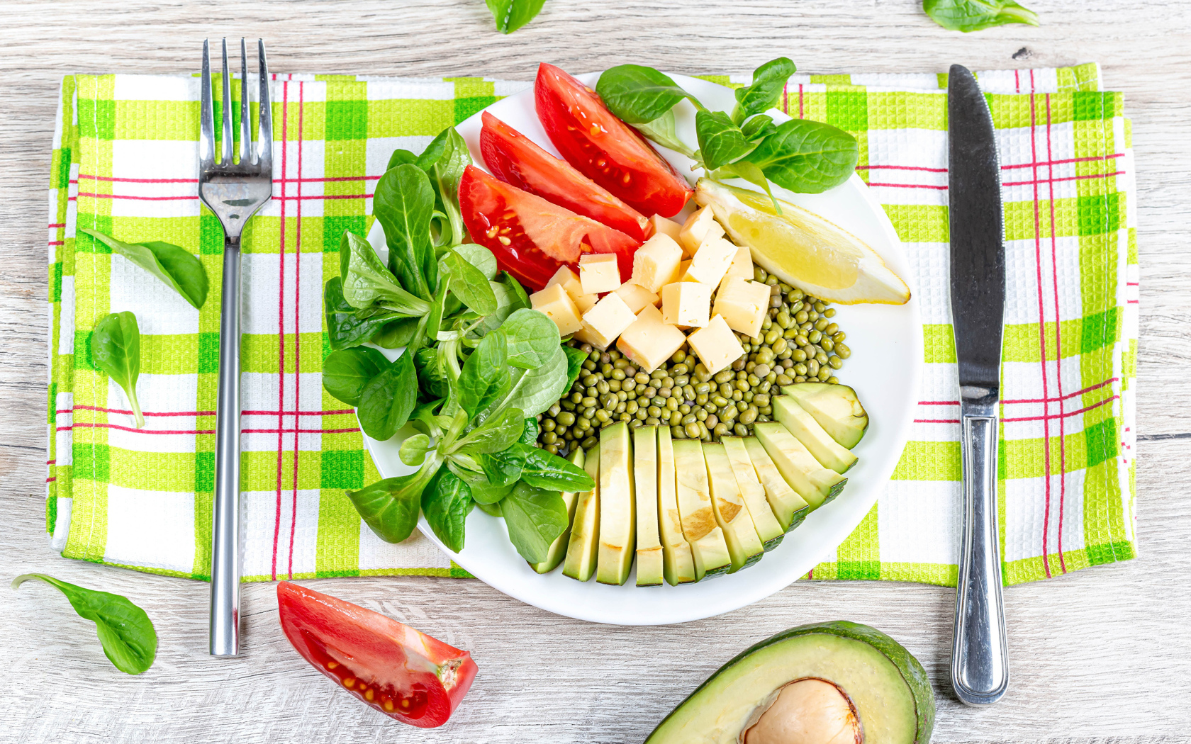 Аппетитные  свежие овощи с сыром и лимоном на тарелке 