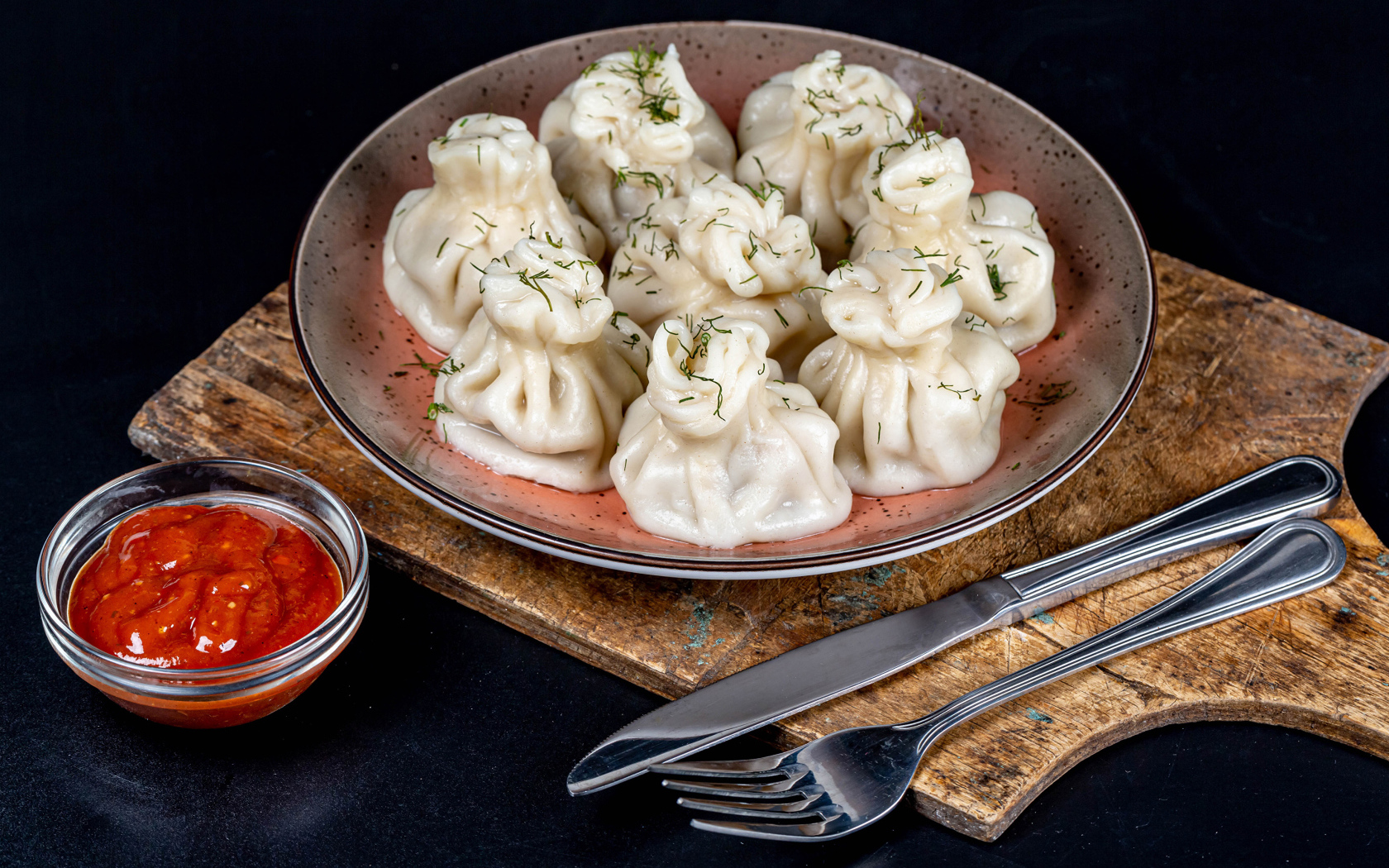 Вкусные горячие хинкали на столе с соусом