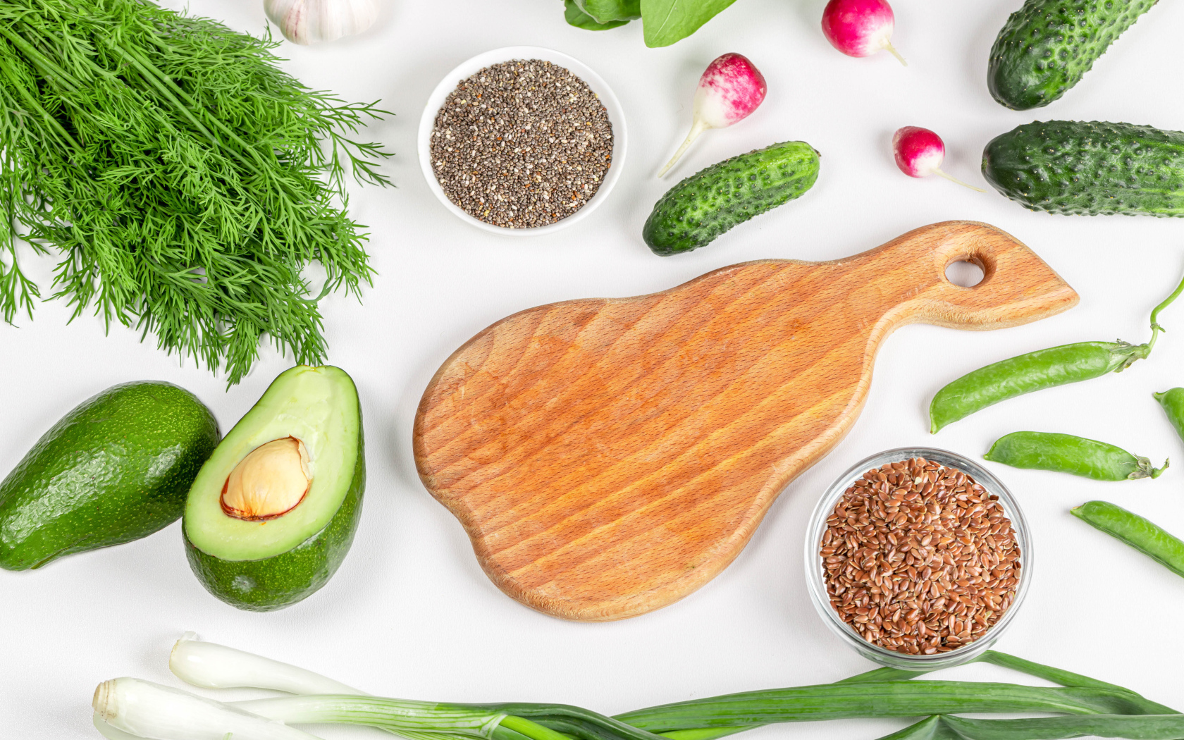 Свежие огурцы, авокадо, редис и укропом на столе с зернами