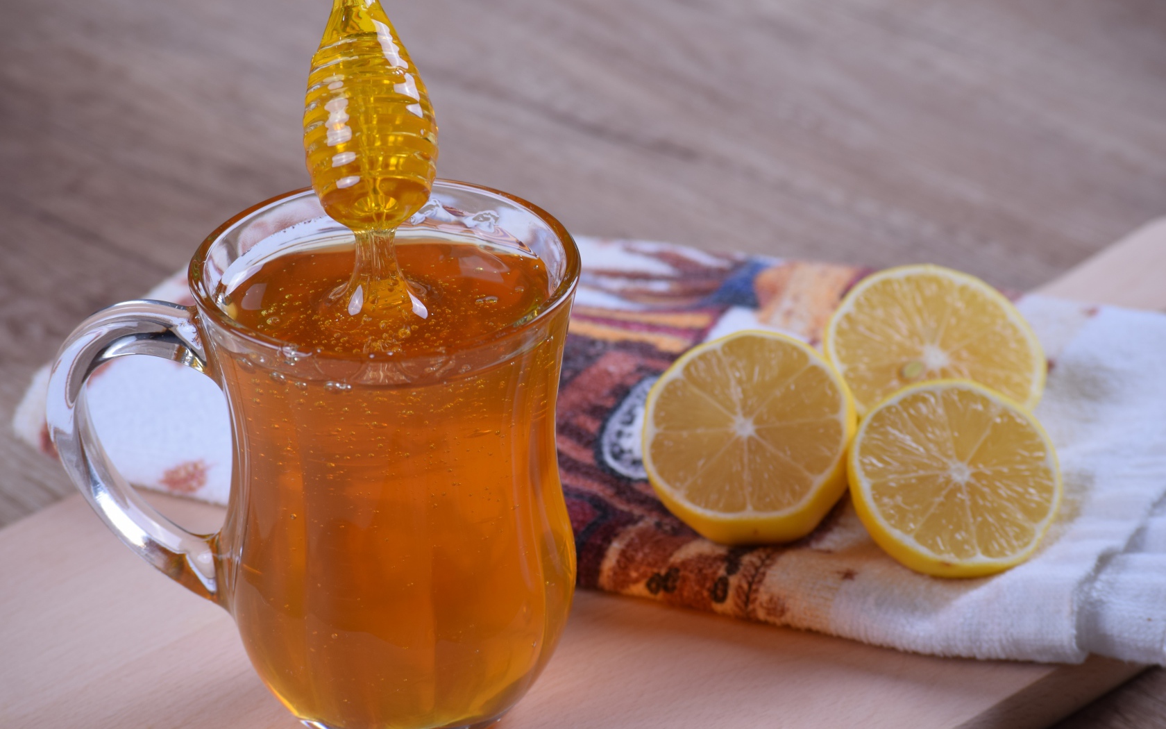Стеклянная кружка с медом на столе с лимоном