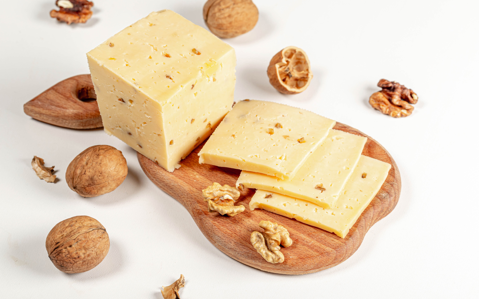 Твердый сыр на доске с грецкими орехами 