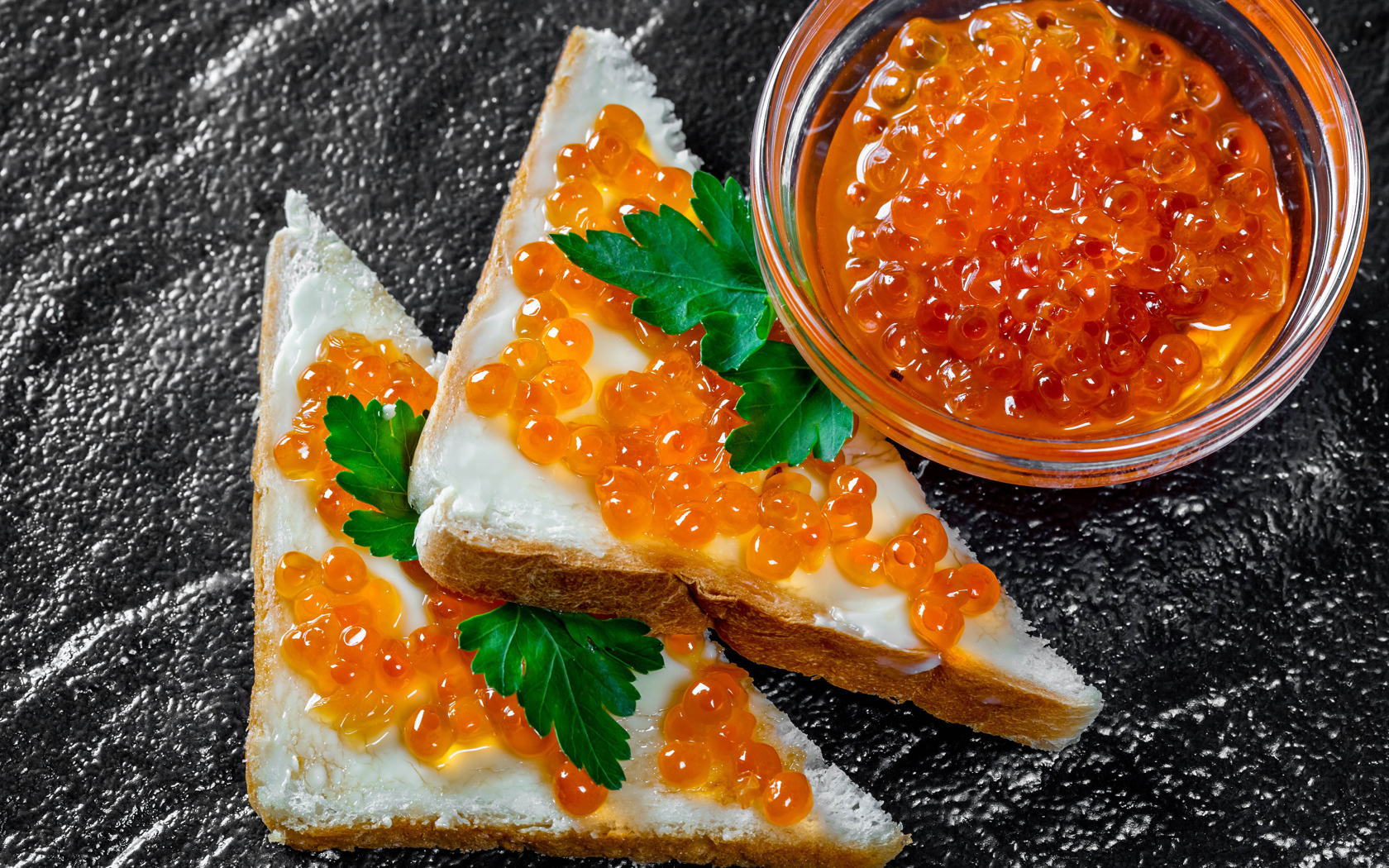 Два бутерброда с красной икрой на столе