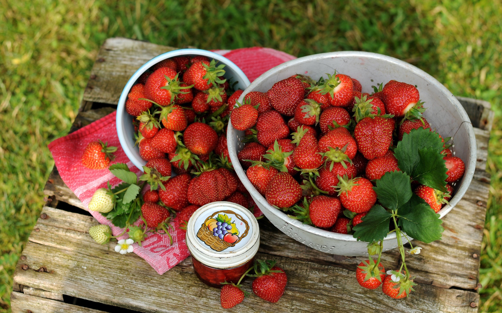 Много спелой ароматной клубники на столе с джемом 