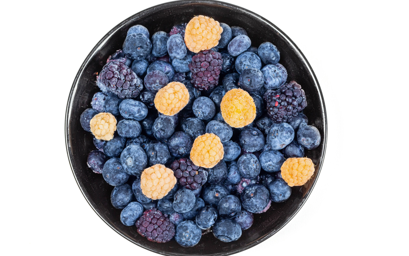 Миска с замороженными ягодами черники и ежевики на белом фоне