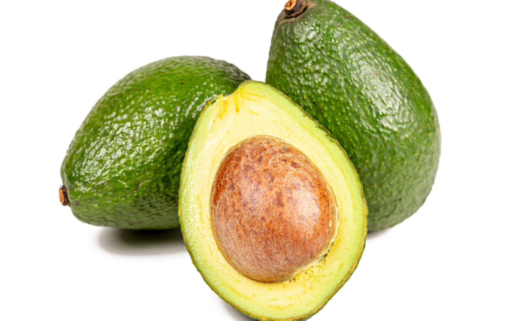 Green avocado fruit on white background