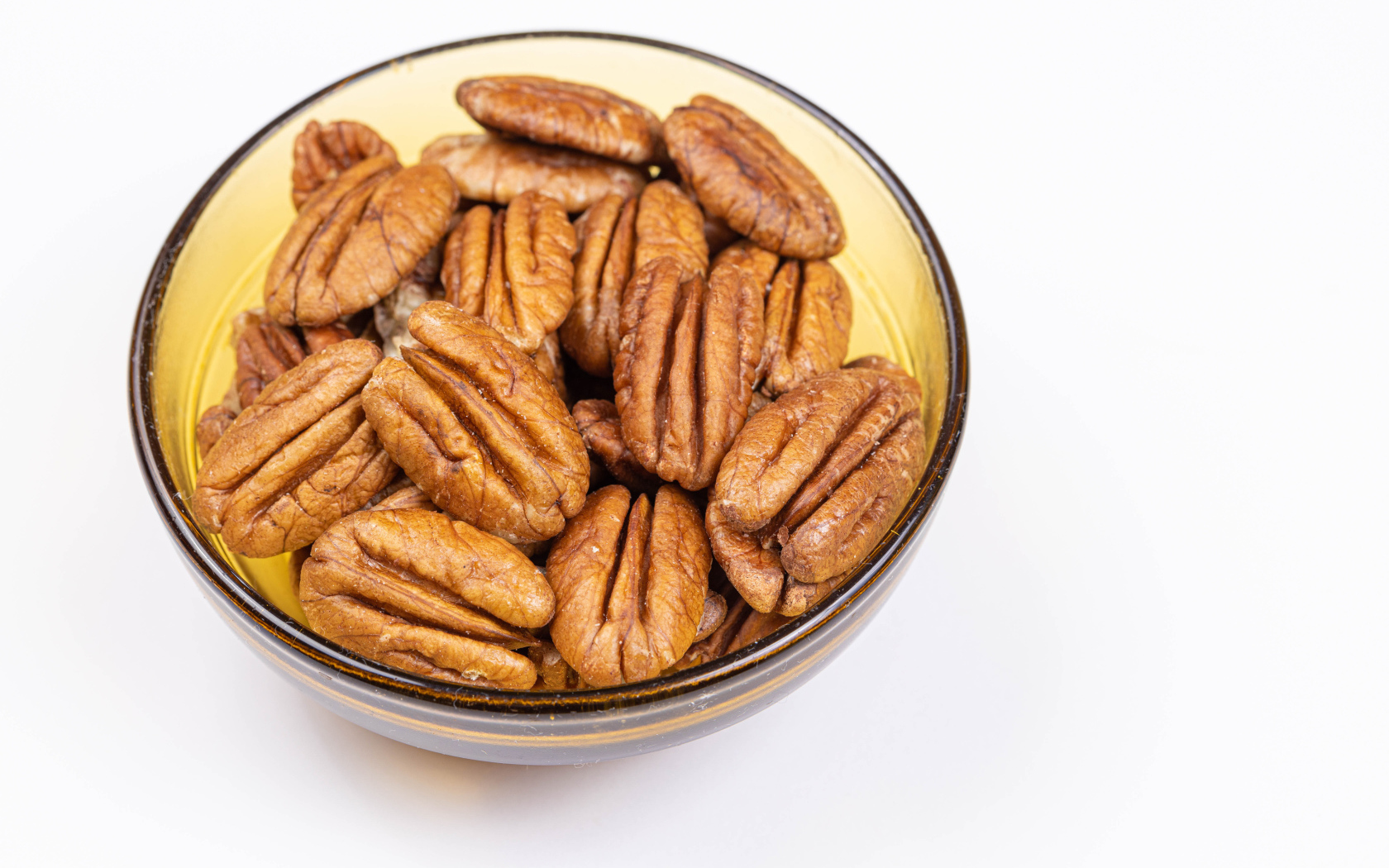 Ядра орехов в миске на белом фоне
