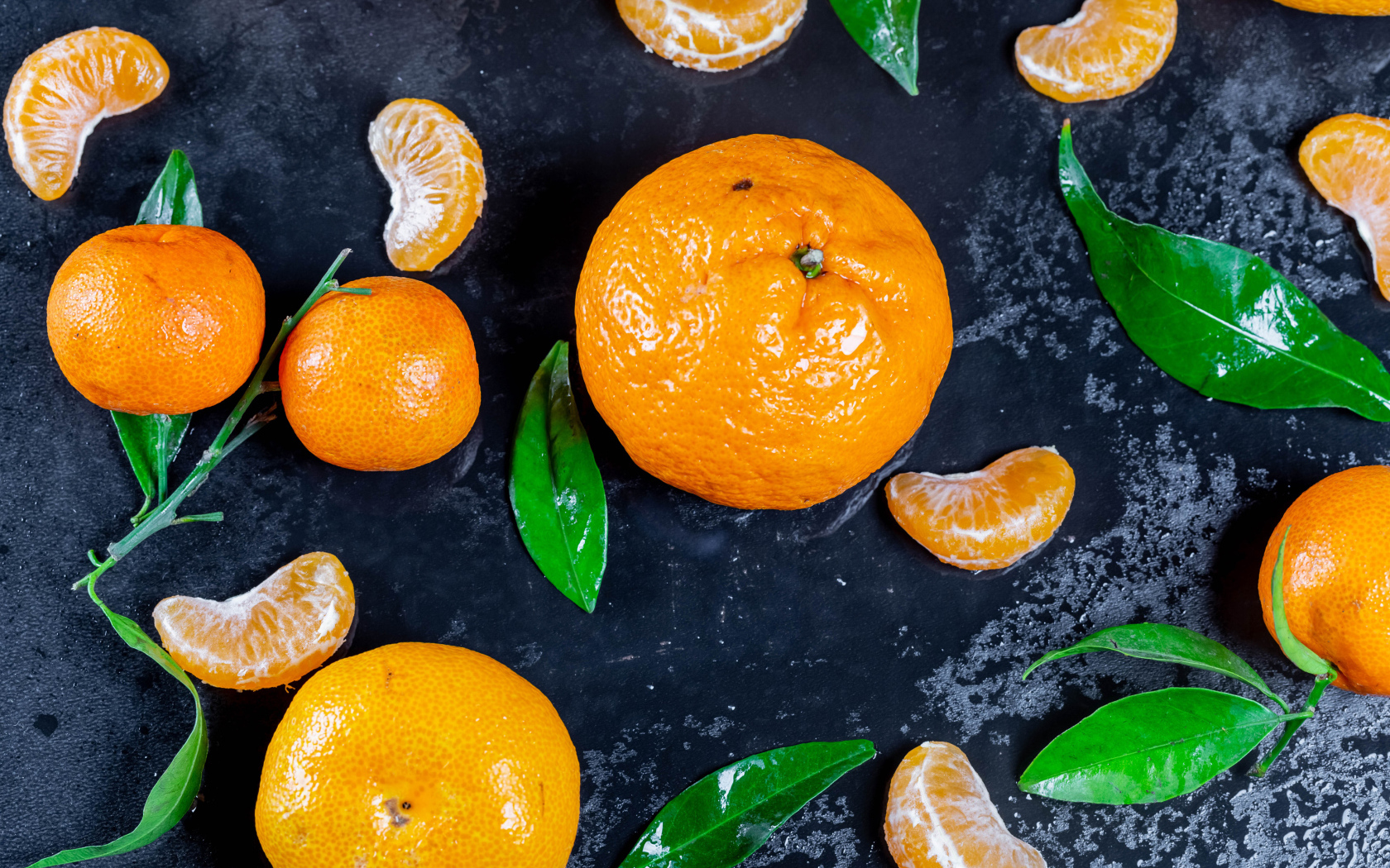 Оранжевые мандарины на мокрой поверхности 