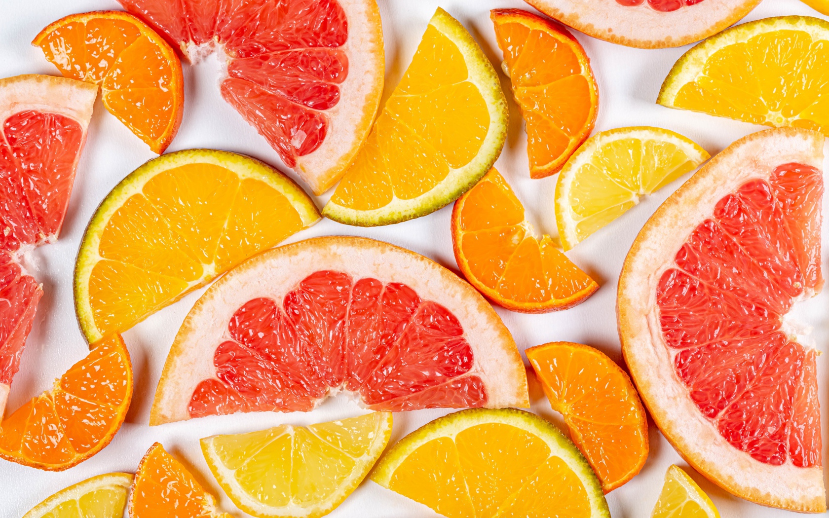 Кусочки апельсина, лимона и грейпфрута на белом фоне