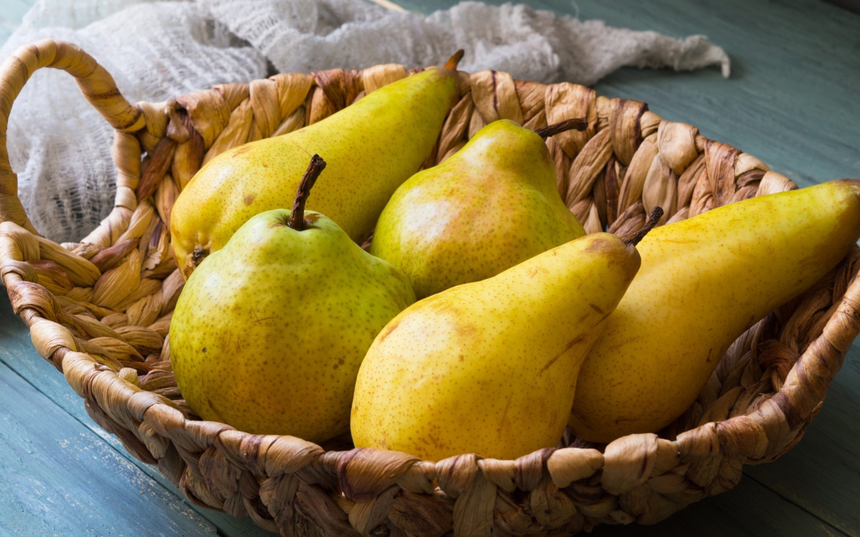 Спелые груши лежат в корзине на столе