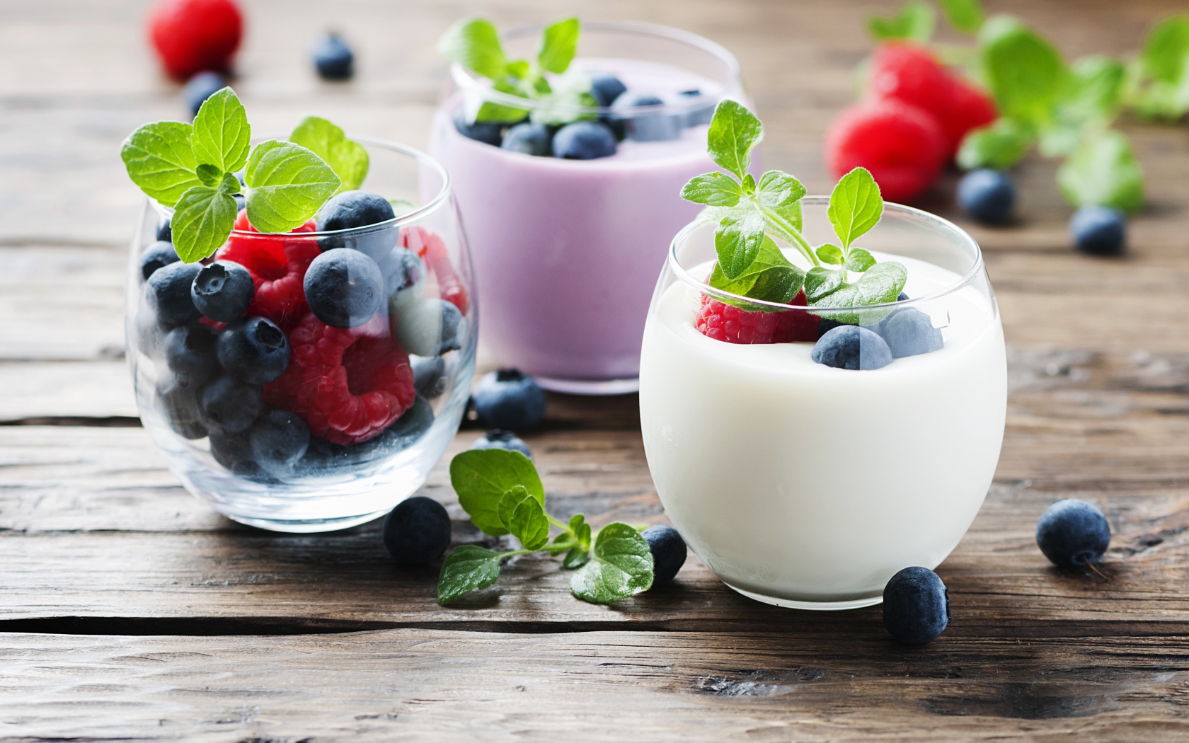 Вкусный йогурт с ягодами черники и малины на столе 