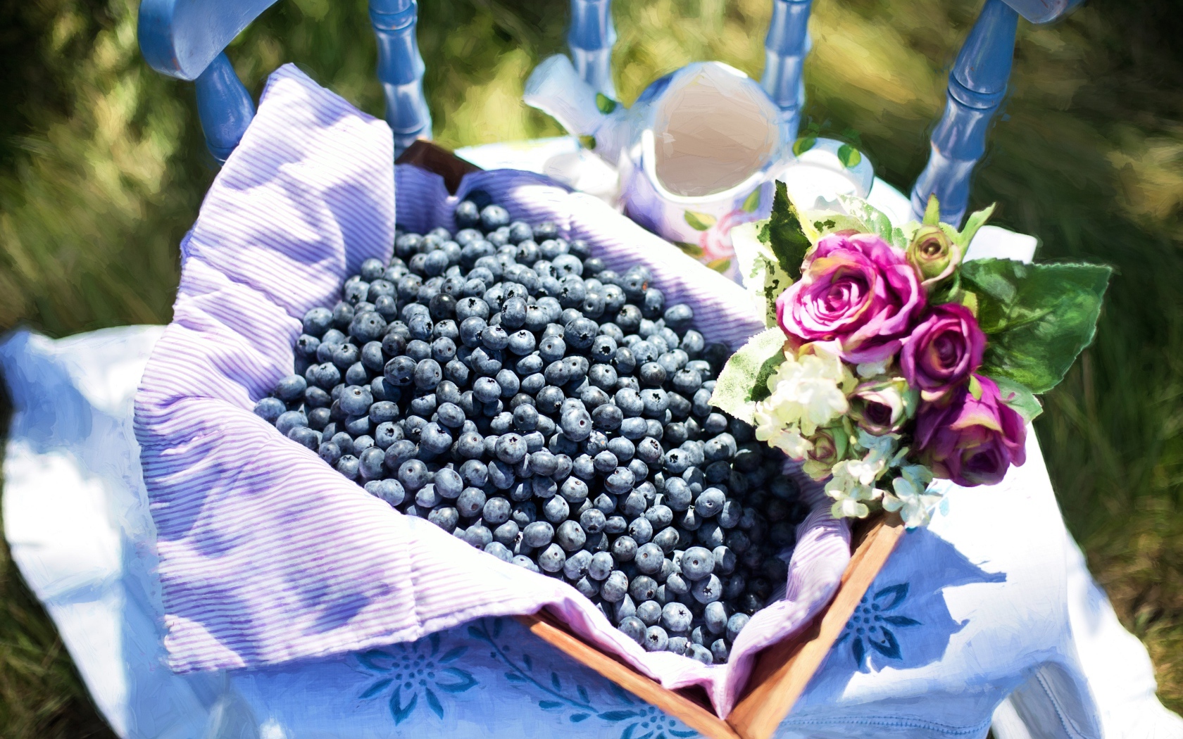 Корзина со спелыми ягодами черники стоит на столе