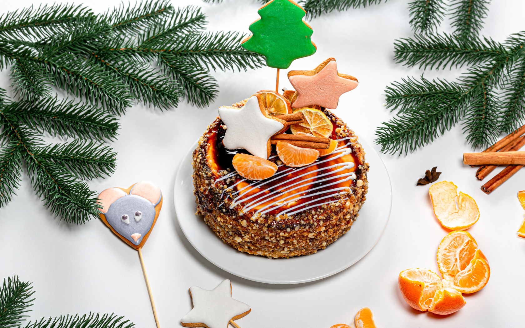 Праздничный торт на столе с мандаринами и еловыми ветками