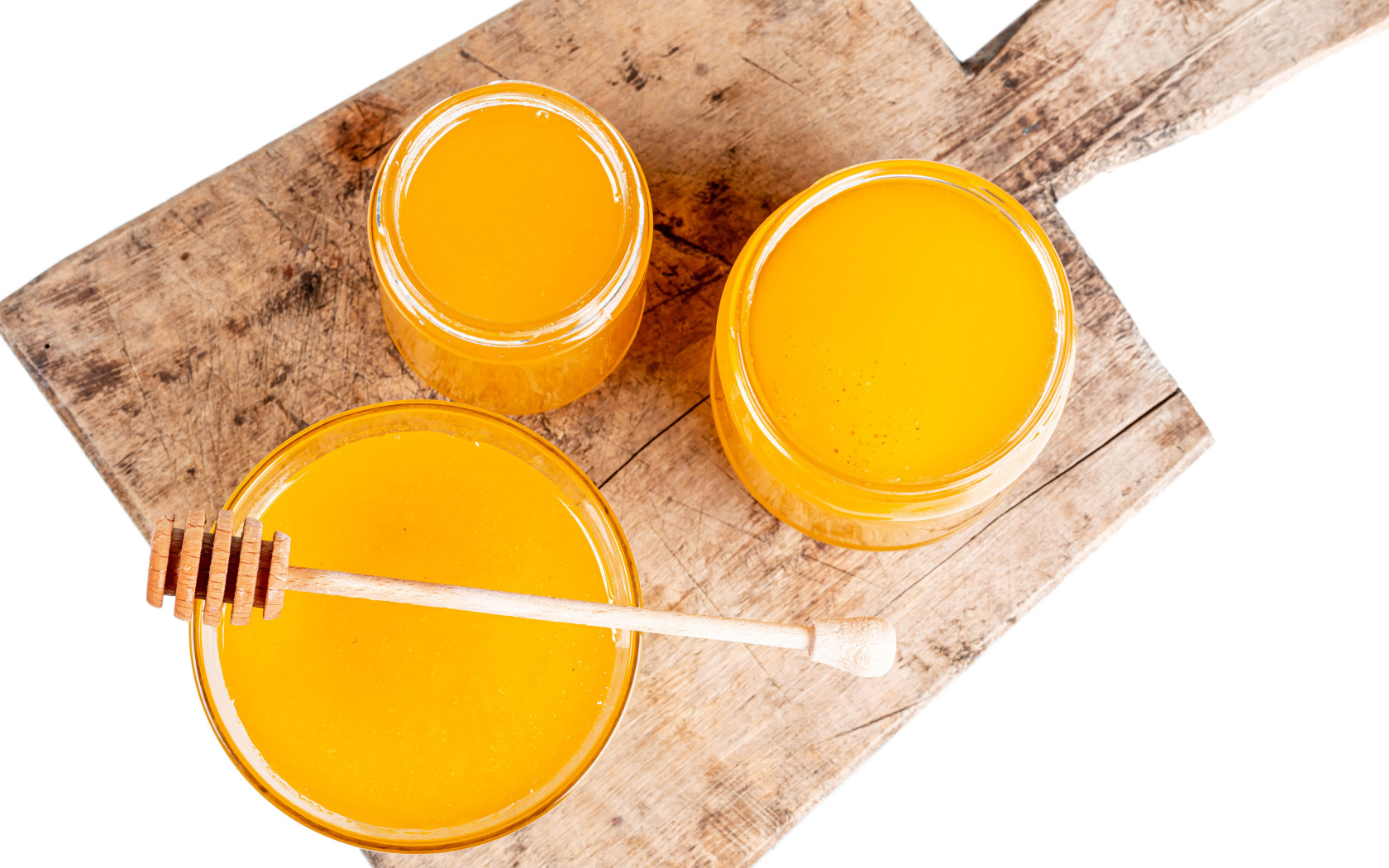 Fresh honey in jars on wooden board on white background