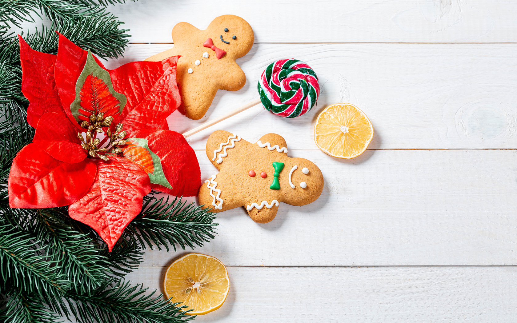 Праздничное печенье с леденцом и еловой веткой на столе 