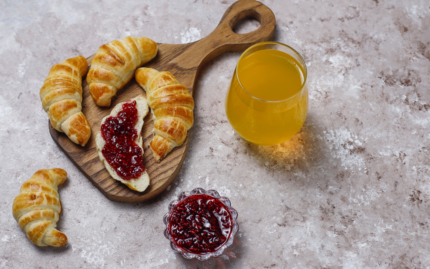 Сок на столе с круассанами и джемом