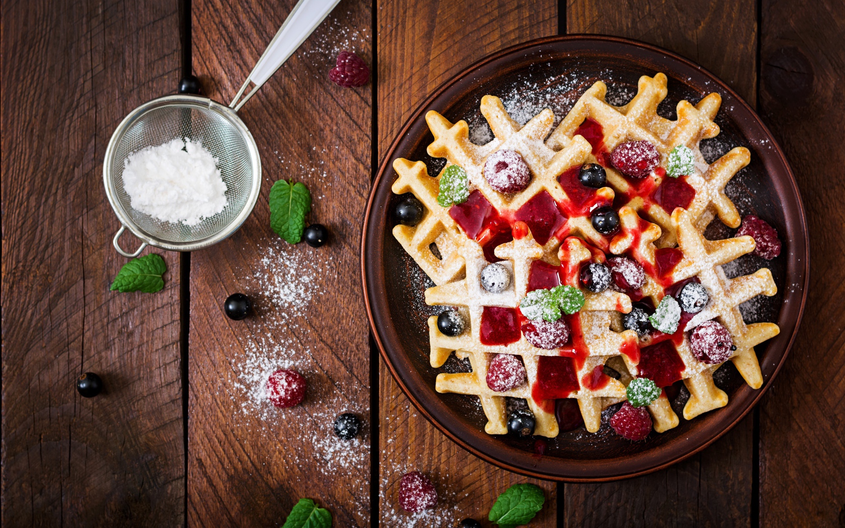 Сладкие медовые вафли на тарелке с ягодами и джемом и сахарной пудрой 