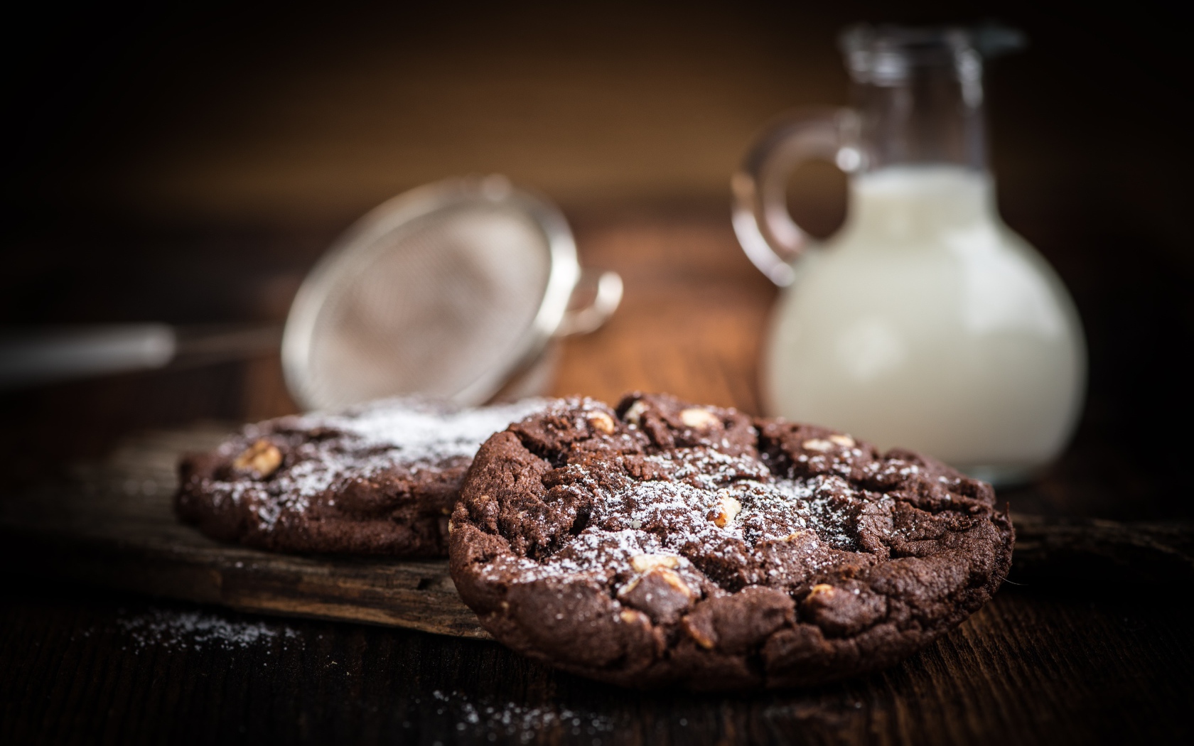 Вкусное шоколадное печенье с орехами на столе с молоком